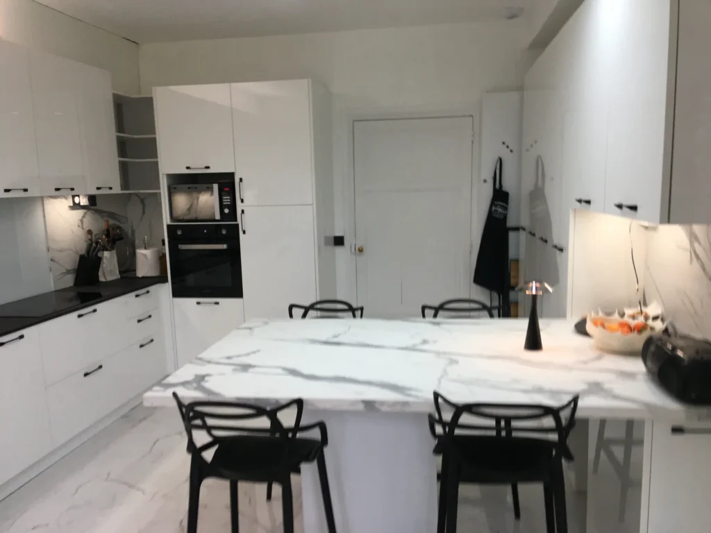 Cuisine blanche brillante avec crédence effet marbre et îlot central par Archit Cuisine à Bergerac, vue 2